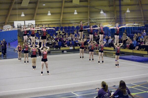 Gymnasts holding shoulder balances in formation during a group routine at the 2012 club display