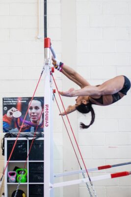 Gymnast circling the uneven bar