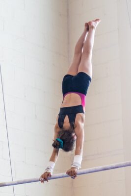 Gymnast holding a handstand on the uneven bar