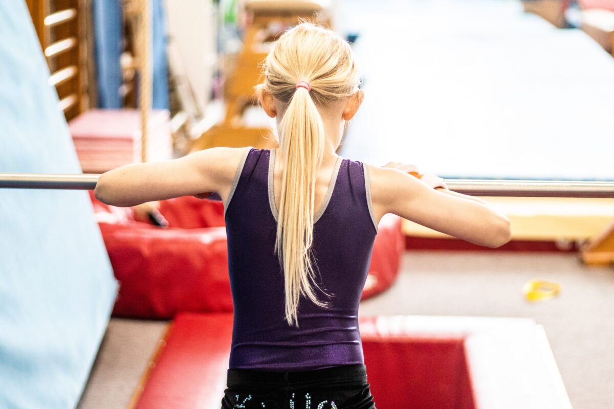 Gymnast holding a handstand on the uneven bar
