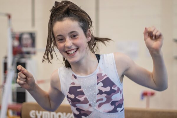 Gymnast celebrating with fists raised and a big smile